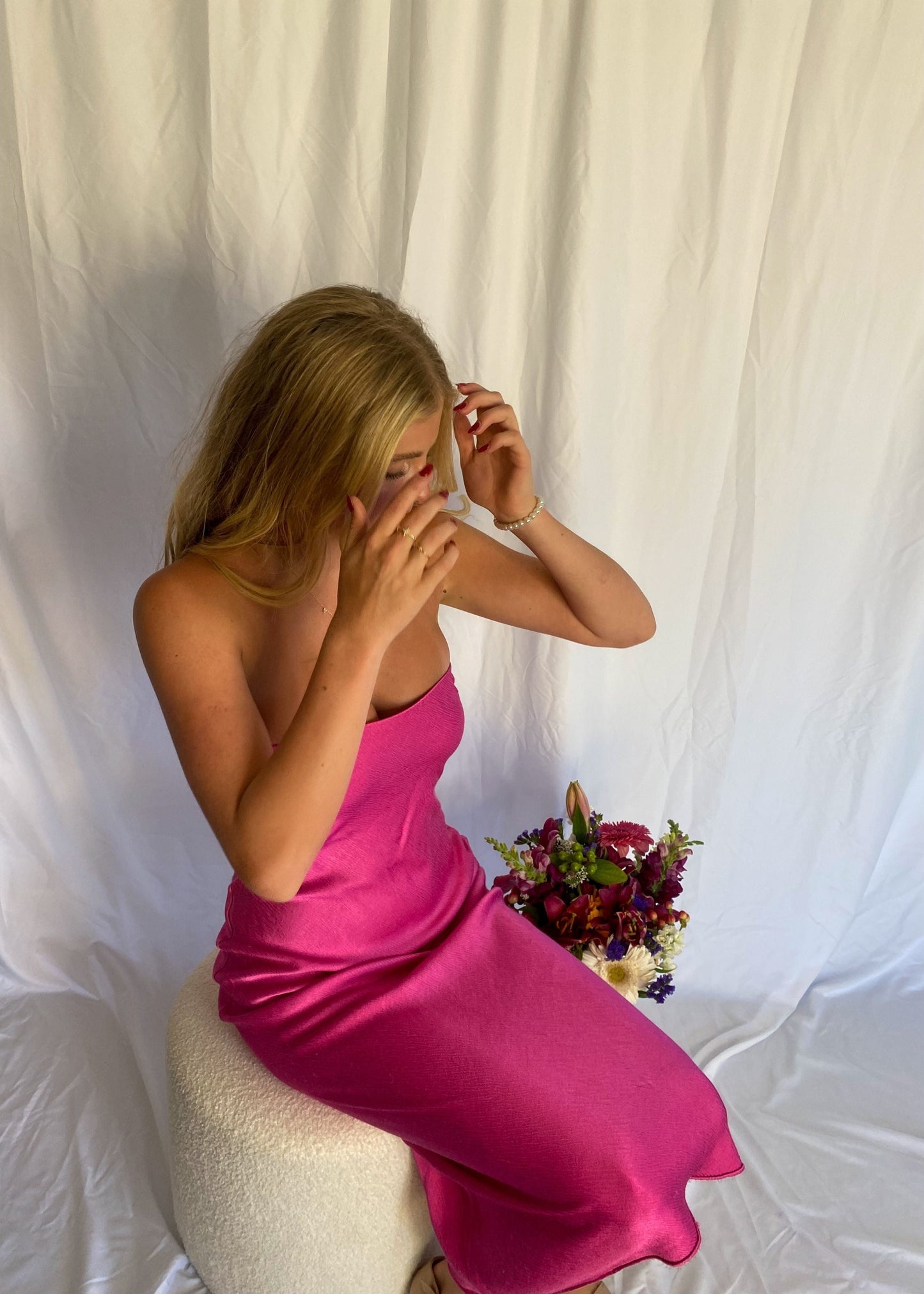 Bec and Bridge Moondance Midi Dress in Hot Pink, Size 6 and 10. Perfect for events like formals, 21sts, races etc. Silky/Satiny feel slight flow to dress. Sitting view of dress.