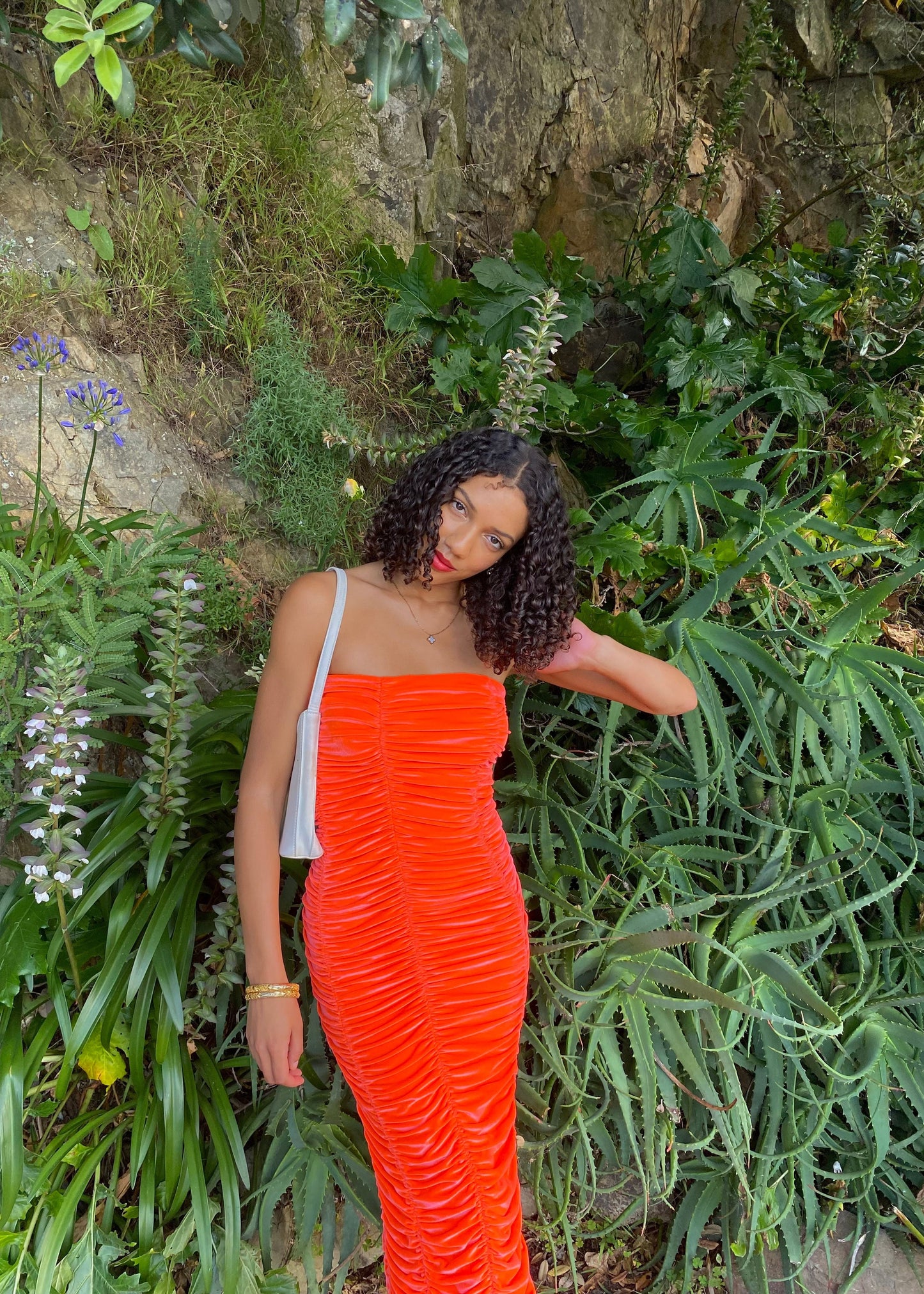 John Christopher Rogers Wiggle Dress in Orange. Best fits a Size 8. Rich velvet material this is a dress to standout in with it's almost fluorescent shade. Strapless design with zip up back. Perfect for formal events where you want to stand out. Front on view of dress.
