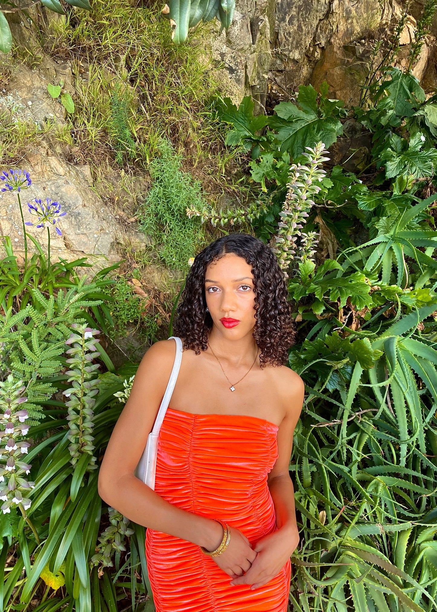 John Christopher Rogers Wiggle Dress in Orange. Best fits a Size 8. Rich velvet material this is a dress to standout in with it's almost fluorescent shade. Strapless design with zip up back. Perfect for formal events where you want to stand out. Front on up close view of dress.
