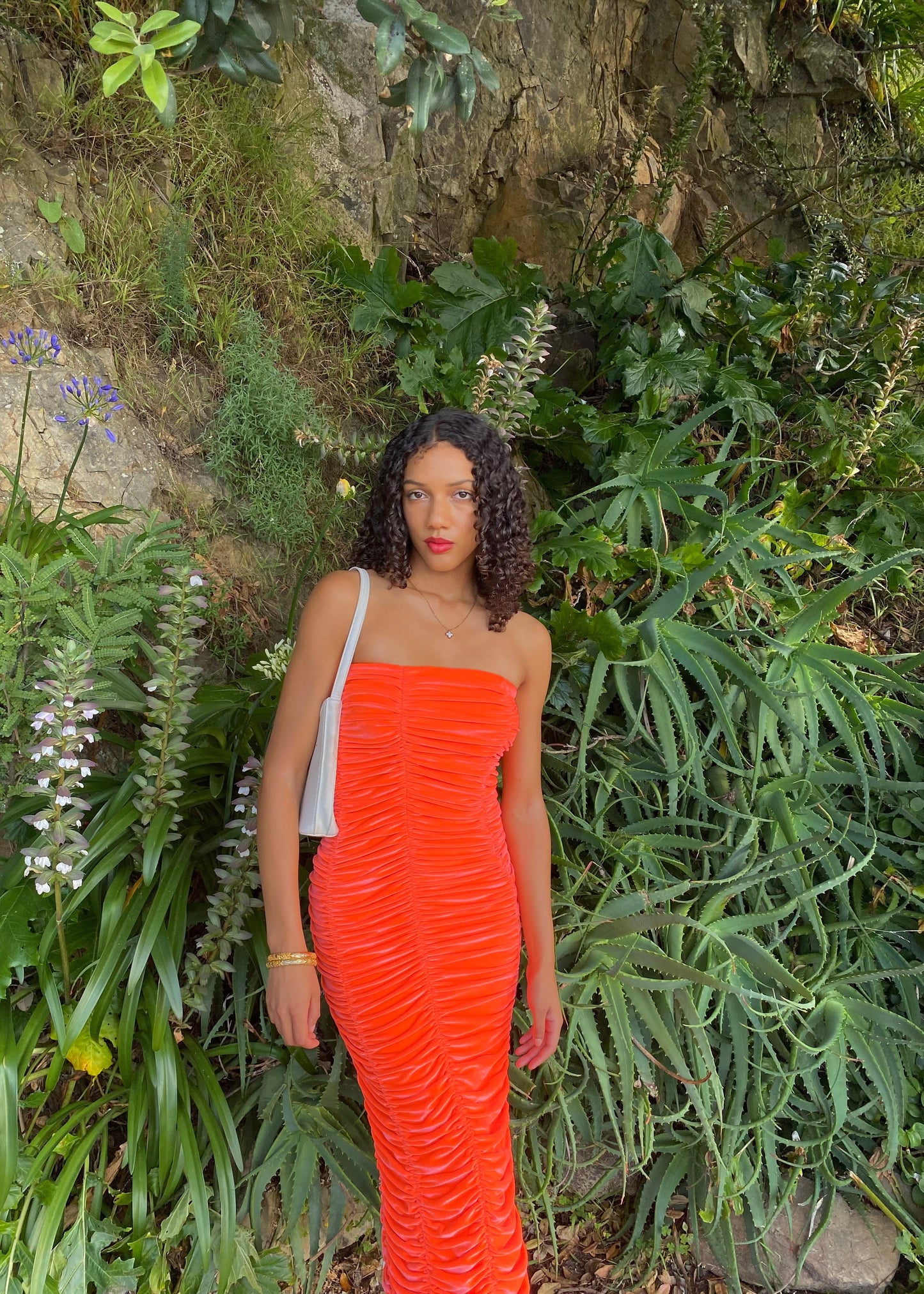 John Christopher Rogers Wiggle Dress in Orange. Best fits a Size 8. Rich velvet material this is a dress to standout in with it's almost fluorescent shade. Strapless design with zip up back. Perfect for formal events where you want to stand out. Front on view of dress.