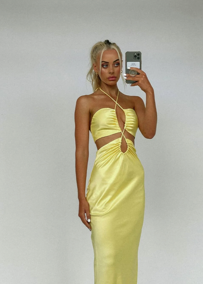 Jagger and Stone Ruby Maxi in Lemon, Size 6, 8 and 12. Featuring a unique design of intersecting straps on the torso area where the skirt and bust connect and again above the bust piece. Perfect for formals, races, birthdays etc. Front on slightly side view of dress