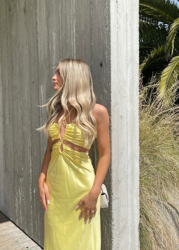 Jagger and Stone Ruby Maxi in Lemon, Size 6, 8 and 12. Featuring a unique design of intersecting straps on the torso area where the skirt and bust connect and again above the bust piece. Perfect for formals, races, birthdays etc. Front on side view of dress