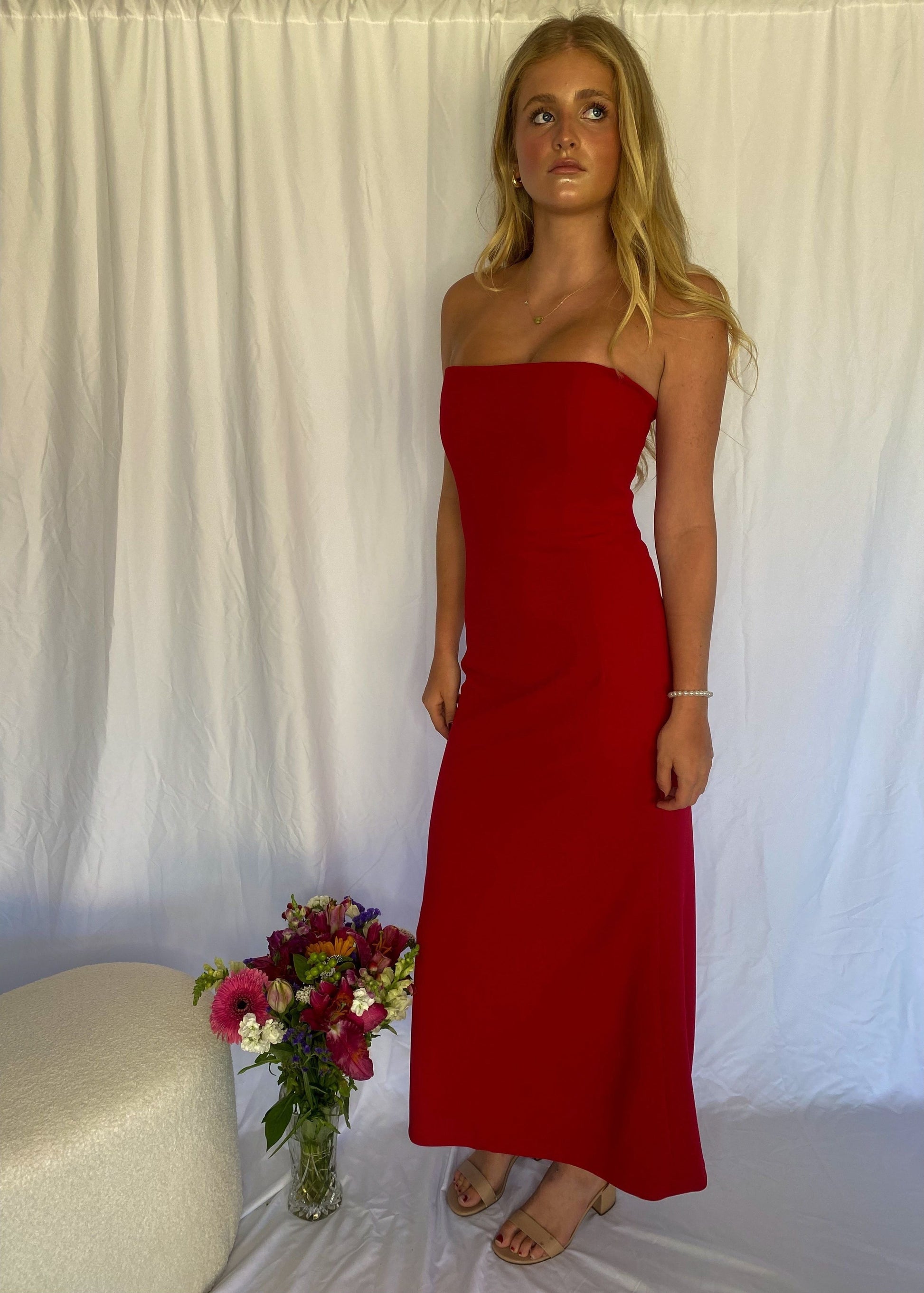 Red strapless full length dress. Top bit of dress has boning like a corset an zip up back. Size XS best fitted to a 8 - small 10. Standing up front/side view of dress