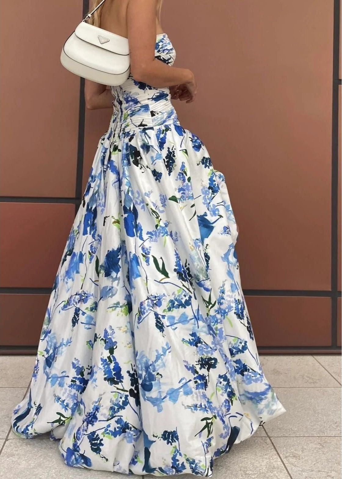 Aje Violet Bubblehem Maxi Dress in Blue Floral, Size 8. Zip up back. Side split on leg up to mid thigh. Tight fitting (with stretch) bust and torso and puffy bottom. Close up side view off the dress.