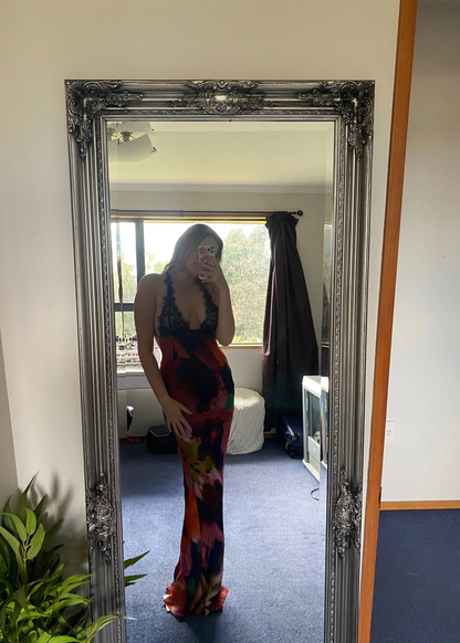 Rat and Boa Paola Maxi Slip Dress, Size L. Featuring a moody, abstract floral print and finished with delicate black lace detailing, it's a floor-skimming slip with delicate, criss-crossing straps and a daringly low-cut back. Perfect for formal events. Front on view of dress.