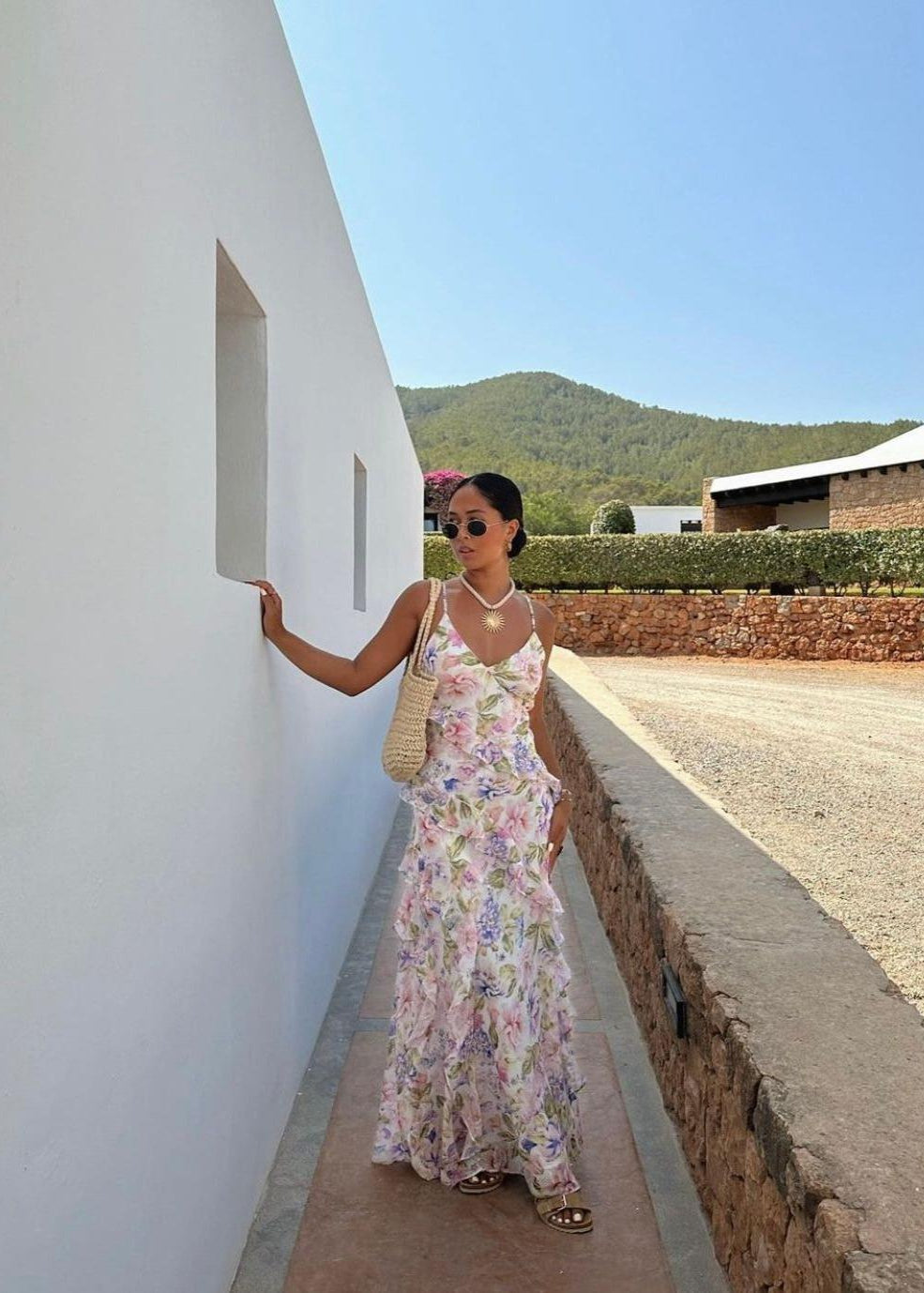 Poppy Floral Ruffle Maxi Dress, Size 10. Featuring a v-neckline with adjustable spaghetti straps, back waist tie and a low back. This dress has an asymmetrical ruffle detail that wraps around the body and a concealed zip fastening on the side of the dress. Colours are white, pink, green and purple/blue. Perfect for formals, weddings, birthdays etc. Front on full length view.