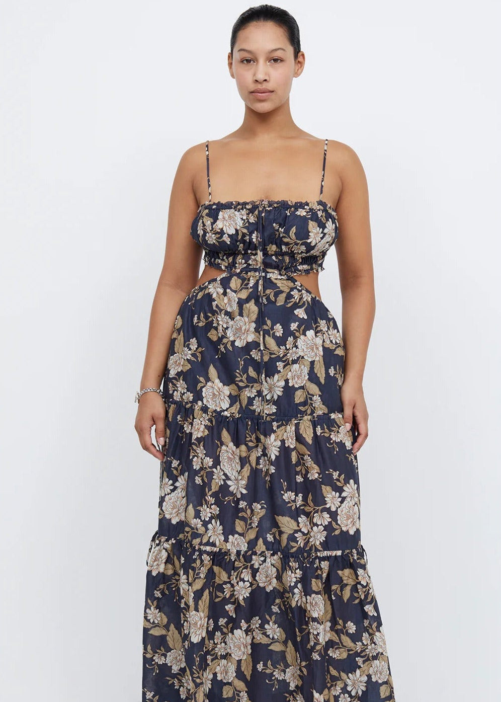 Bec and Bridge Alexandra Tie Maxi Dress, Size 16. Navy with some floral patterning that is cream/light brown. Thin flowy material. Small stomach cut outs on the side. Slightly adjustability at back and very stretchy. Front on view of dress