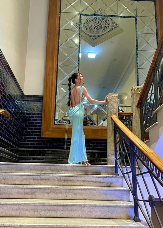 Melani the Label Cristinaa Gown in Aqua, Size 6/XS. Featuring a stunning draping low back with very adjustable straps to have the front lower or higher depending on preference the strap strings also cascade down the back of the dress which has a small train depending on your height. This is a tighter fitting dress. Perfect for formal events. Back view of dress.