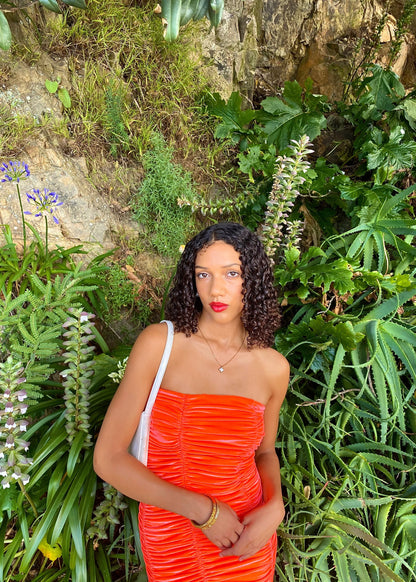 John Christopher Rogers Wiggle Dress in Orange. Best fits a Size 8. Rich velvet material this is a dress to standout in with it's almost fluorescent shade. Strapless design with zip up back. Perfect for formal events where you want to stand out. Front on up close view of dress.
