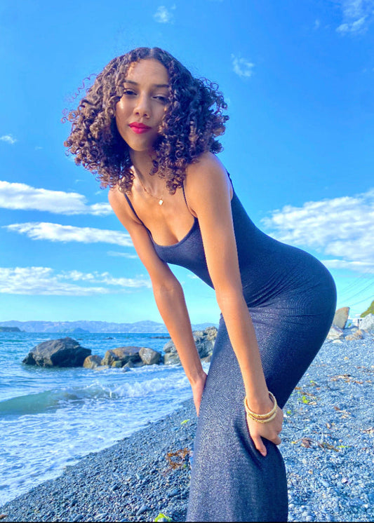 SKIMS Long Slip Dress in Shimmer Onyx, Size S. Featuring a body hugging fit, straight neck and adjustable spaghetti straps. Featuring a gorgeous shimmer detail on the dress. Can be dressed up or down. Front on side view of dress.
