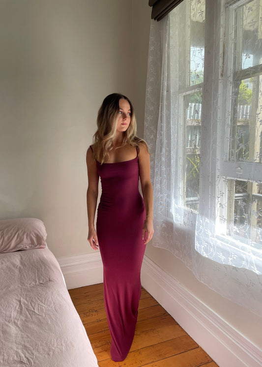 SKIMS Long Slip Dress in Wine Red, Size S. Featuring a body hugging fit, straight neck and adjustable spaghetti straps. Can be dressed up or down. Front on full length view of dress.