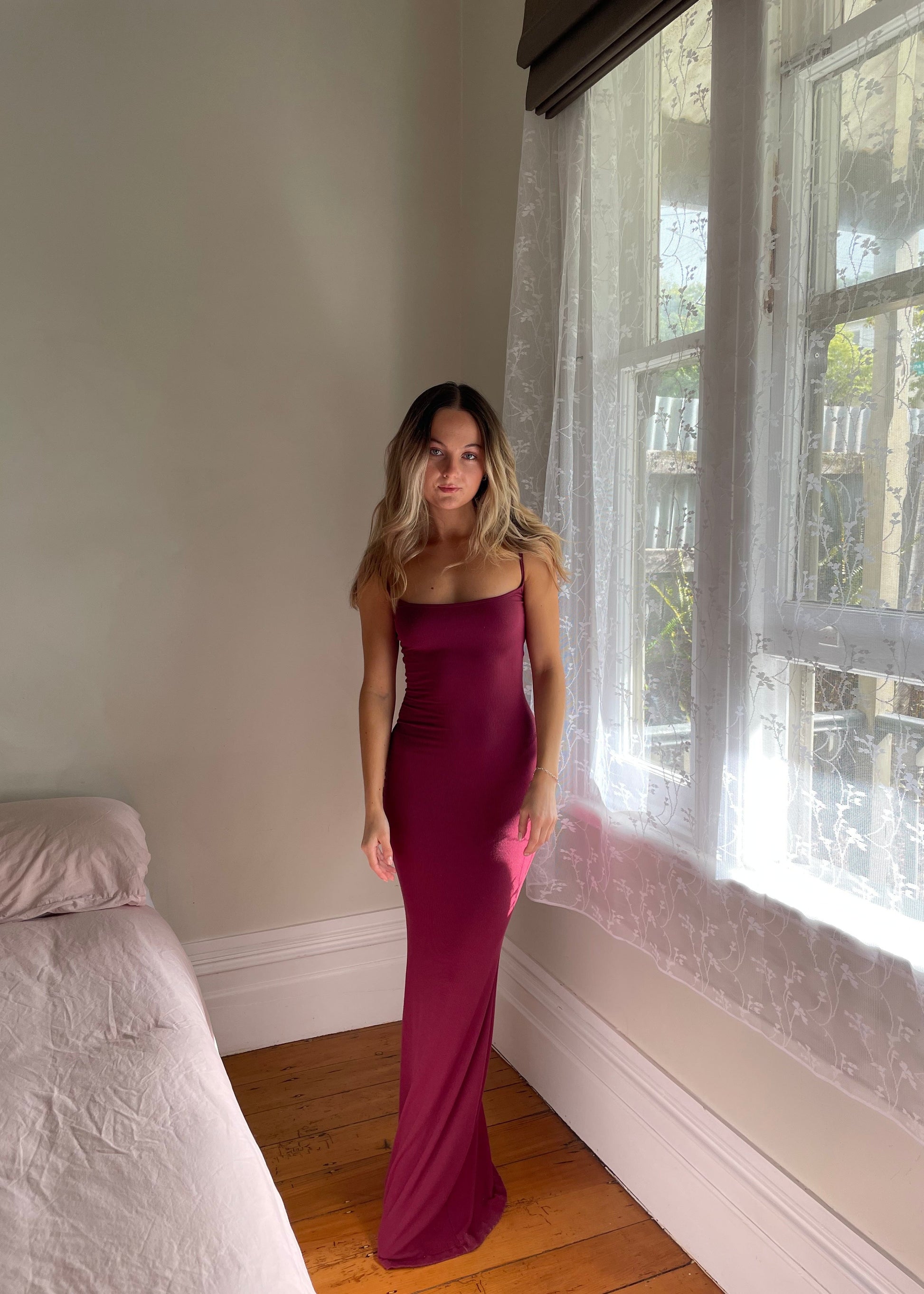 SKIMS Long Slip Dress in Wine Red, Size S. Featuring a body hugging fit, straight neck and adjustable spaghetti straps. Can be dressed up or down. Front on view of dress.