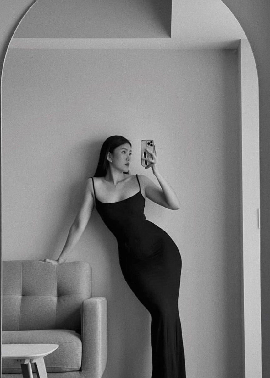 SKIMS Long Slip Dress in Onyx, Size XS and M. Featuring a body hugging fit, straight neck and adjustable spaghetti straps. Can be dressed up or down. Front view of dress.
