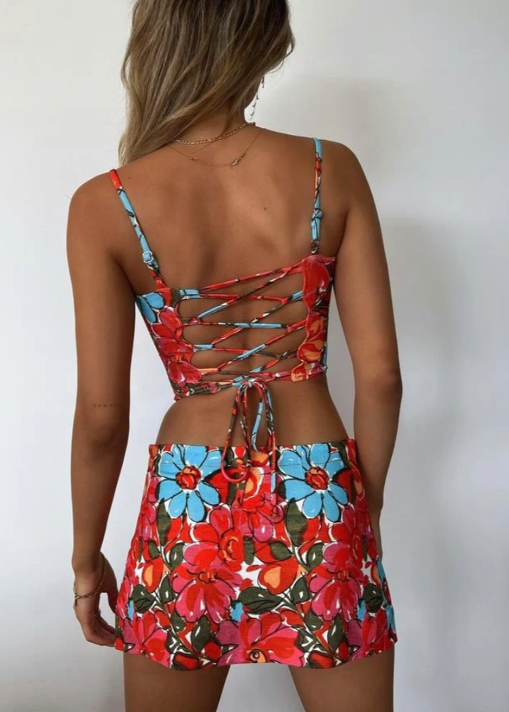 Miaou Parsian Flower Corset and Micro Mini Skirt Set, Size S. Colour scheme is pink, blue and red mostly. Featuring a lace up back and skirt which also has a small side split. This micro mini is very small. Top can be rented separately. Perfect for festivals, 18th's, bottomless brunch etc. Back full view of set.