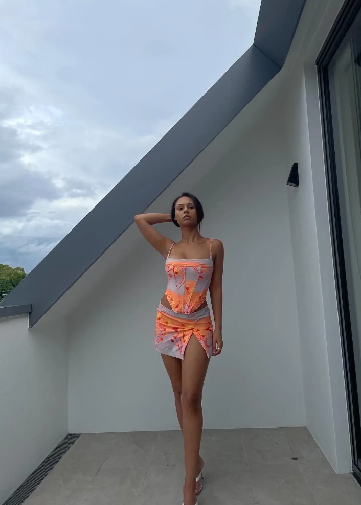 Miaou Sunrise Corset and Micro Mini Skirt Set, Size XS top ONLY and M Set. Colour scheme is cloud colour with orange and a hint of red. mostly. Featuring a lace up back and skirt which also has a small side split. This micro mini is very small. Top can be rented separately. Perfect for festivals, 18th's, bottomless brunch etc. Front on full length view of set.