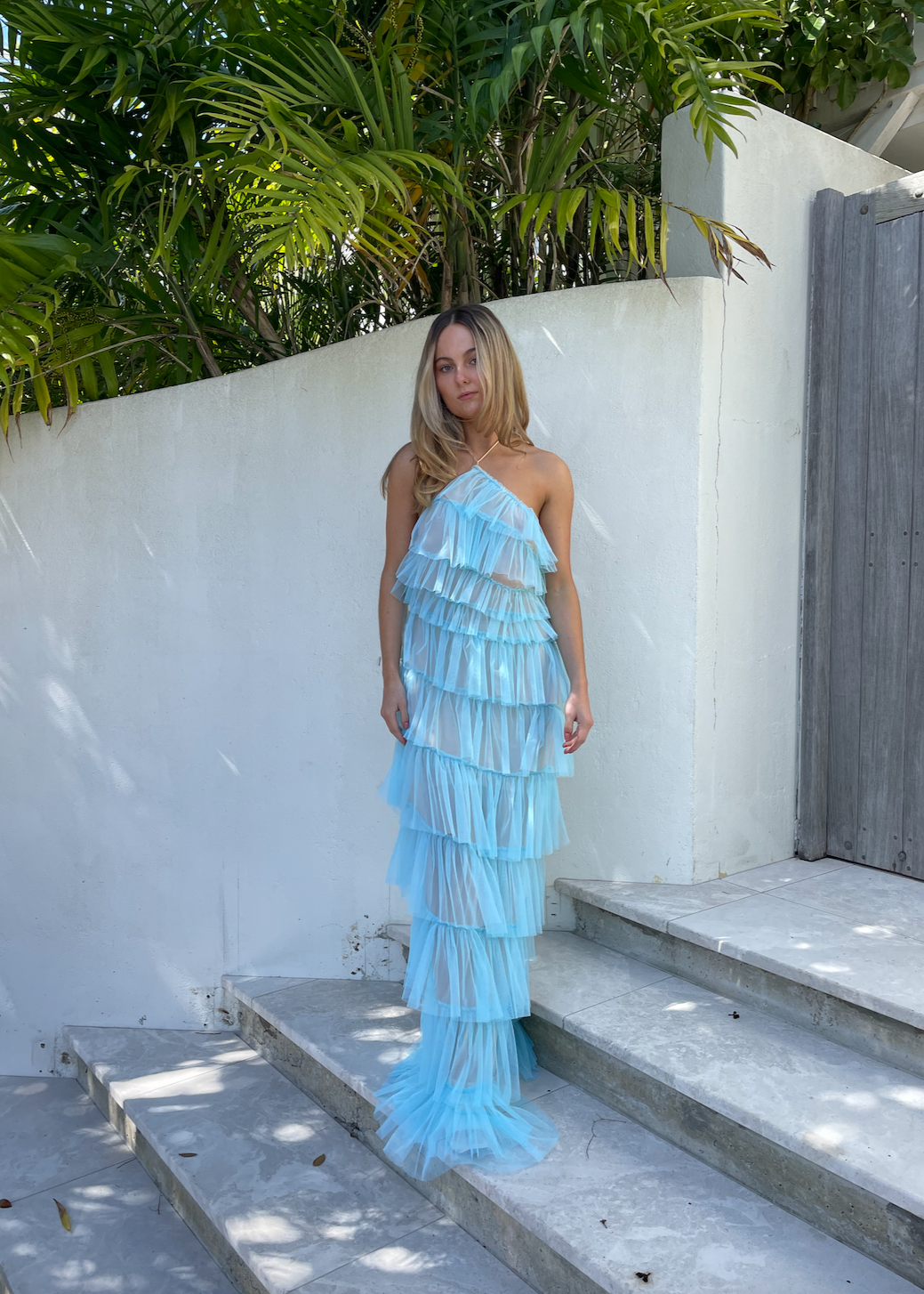 The Bar Henri Gown in Blue, Size US4 (AU8). Featuring Layered tulle fabric with a halter neck tie, side zip closure and side split, along with a low back. Semi Sheer but comes with a nude mini skirt that can be worn under. Perfect for formal events. Front on view.